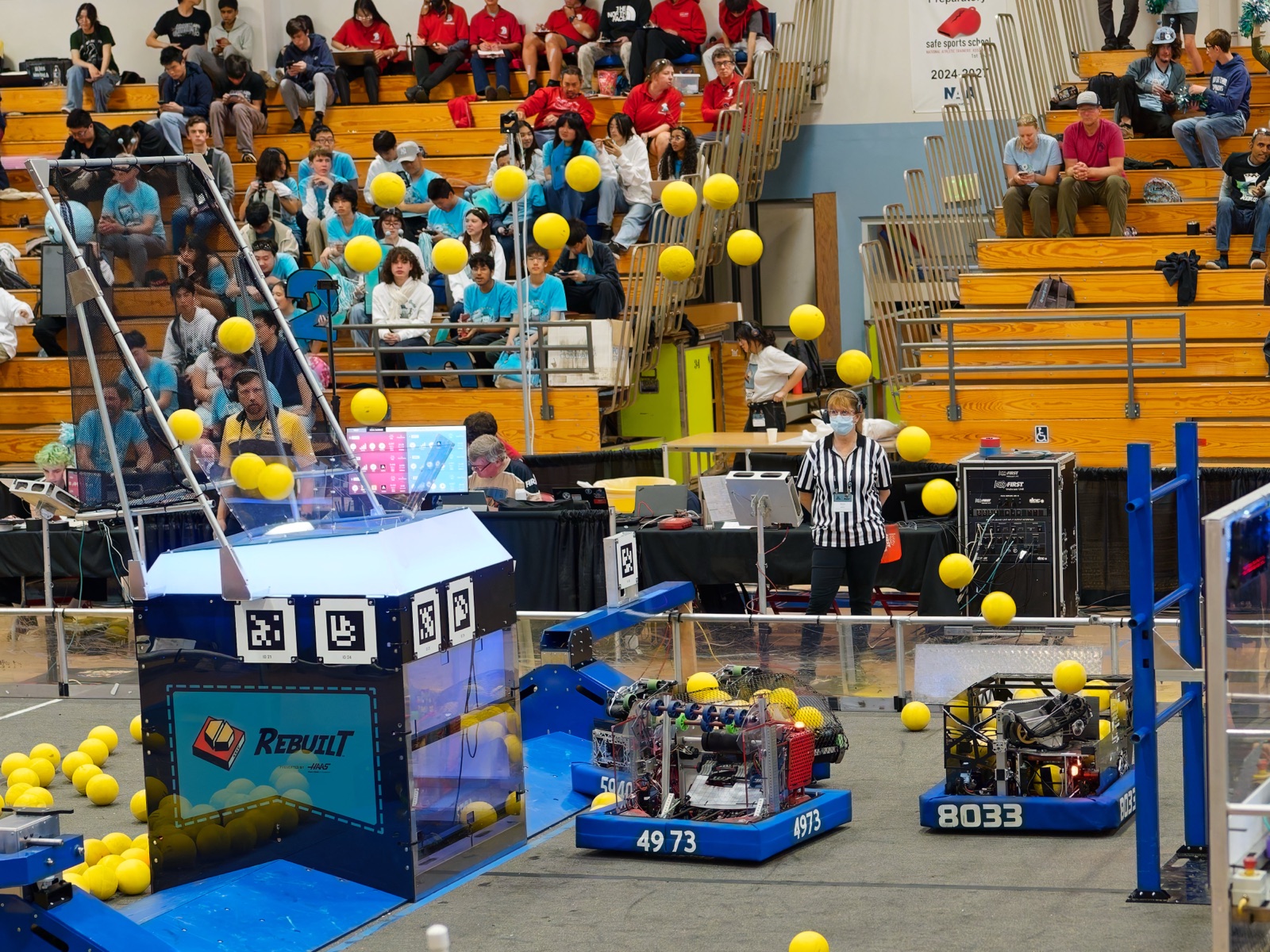 Highlander Robotics' 2026 robot, Wisp, mid-shot, ejecting a foam 'fuel' ball into a competition hub.
